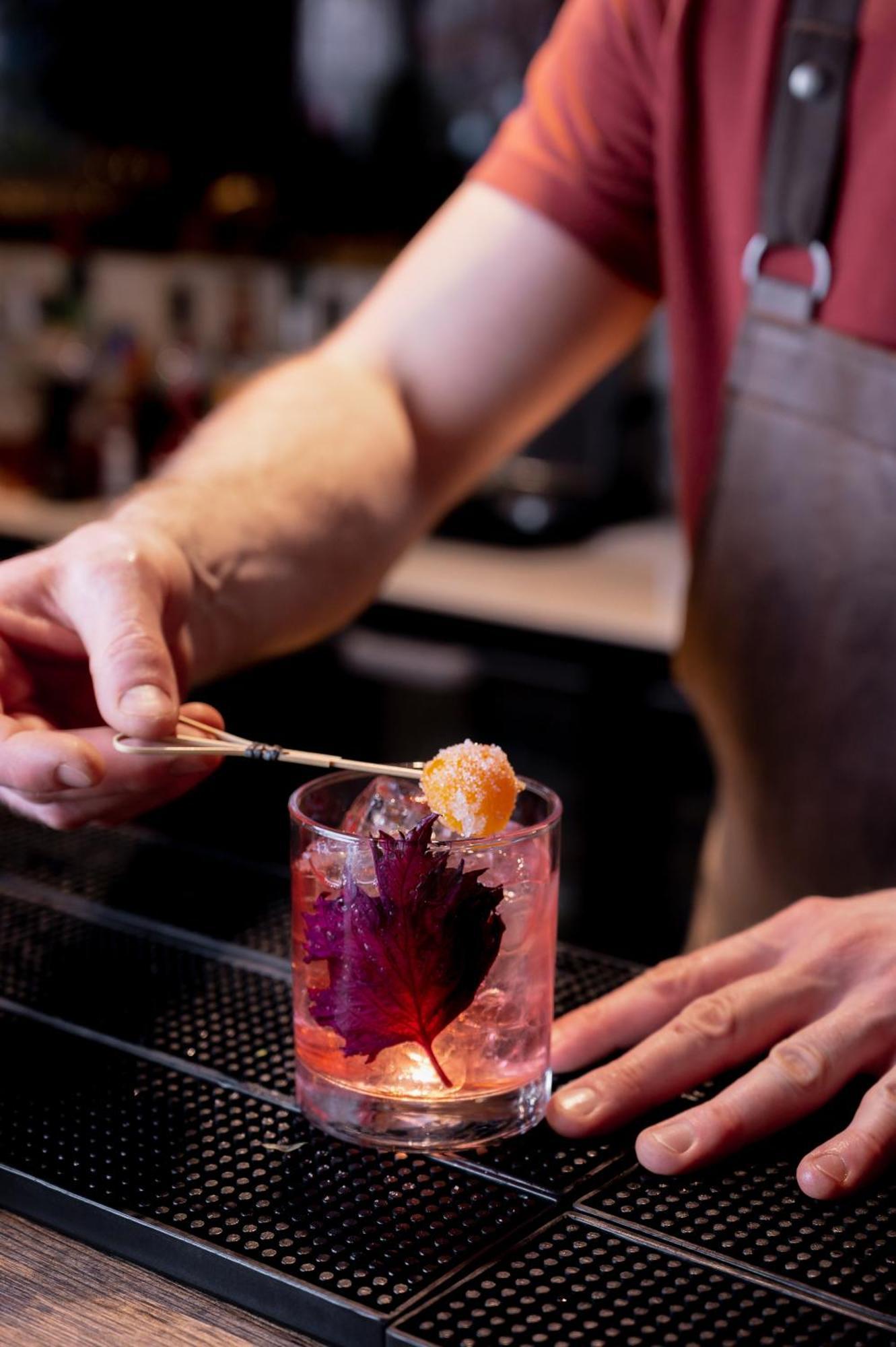 1 Hotel Copenaghen Esterno foto A bartender adding a lemon twist to a cocktail