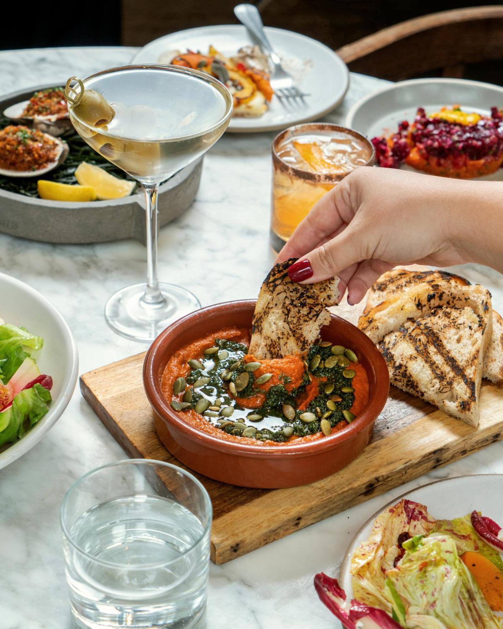 1 Hotel Copenaghen Esterno foto A woman dipping bread into a bowl of hummus